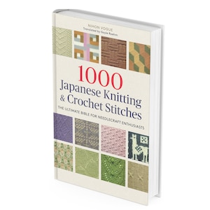 Könnte beinhalten: Ein Hardcover-Buch mit dem Titel "1000 Japanese Knitting & Crochet Stitches" mit cremefarbenem Einband. Der Einband zeigt ein Raster farbiger Stichproben und den Text "THE ULTIMATE BIBLE FOR NEEDLECRAFT ENTHUSIASTS". Das Buch ist von Nihon Vogue.