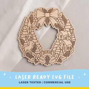 May include: A circular wooden cutout featuring a laser-engraved winter scene. The design includes a large bow at the top, a deer, pine trees, houses with snow-covered roofs, a small bridge, and holly leaves with berries arranged in a wreath shape.