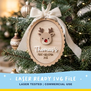 May include: An oval wooden Christmas ornament with a scalloped edge, featuring a layered reindeer head with a red nose, a white ribbon bow, and the text "Thomas's FIRST CHRISTMAS 2026" engraved and layered on the light wood surface.