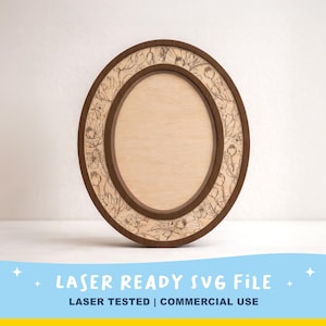 May include: An oval wooden frame featuring a dark brown outer border and a lighter wood inner section. The frame is decorated with a detailed laser-engraved floral pattern consisting of various flowers and leaves surrounding the central opening.