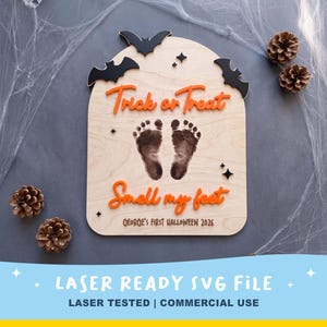 May include: A light-coloured wooden arch-shaped sign featuring black laser-cut bats, orange 3D text reading Trick or Treat and Smell my feet, and a pair of dark baby footprints in the centre. The bottom text reads GEORGE'S FIRST HALLOWEEN 2026.
