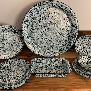 May include: Set of green and white speckled enamelware dishes, including a large platter, two dinner plates, a small baking dish, two bowls, and a set of saucers.
