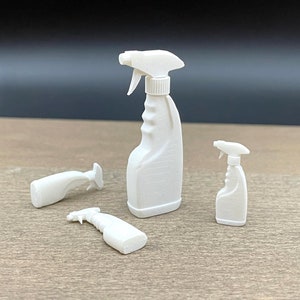 Pode incluir: Três garrafas de spray de plástico branco de diferentes tamanhos. As garrafas têm um bico de pulverização com gatilho e um design texturizado.