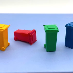 Può includere: Quattro bidoni della spazzatura giocattolo in miniatura di diversi colori: giallo, rosso, verde e blu. I bidoni sono tutti della stessa dimensione e forma, e hanno delle ruote sul fondo.