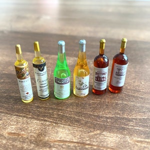 Könnte beinhalten: Sechs Miniaturflaschen Wein aus Glas mit Korkverschlüssen und Etiketten. Die Flaschen sind in einer Reihe auf einer Holzoberfläche angeordnet. Die Etiketten zeigen verschiedene Designs und Texte, darunter "Pont City", "Eiswein", "LYS GENARDE", "BALSOOI LAKE" und "Estates".