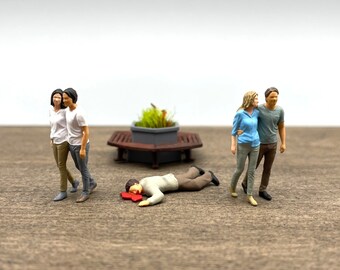Couples marchant et homme blessé. Figurines miniatures. Échelle 1:64