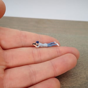 Miniaturas de figuras humanas. Fotógrafos, cinegrafista e apresentador de telejornal. Escala 1:64. Photographer Laying