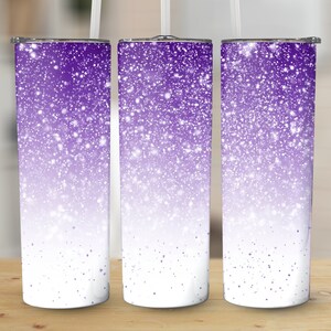 May include: Three stainless steel tumblers with a purple glitter ombre design. The tumblers are white at the bottom and fade to a deep purple at the top.