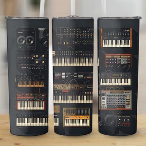 Puede incluir: Tres vasos de acero inoxidable negro con un diseño de sintetizadores y teclados vintage. Los vasos están dispuestos en una fila de izquierda a derecha.