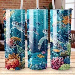 Puede incluir: Tres vasos de acero inoxidable con una escena submarina colorida que presenta tortugas marinas, corales y peces. Los vasos son de color azul claro con una tapa blanca.