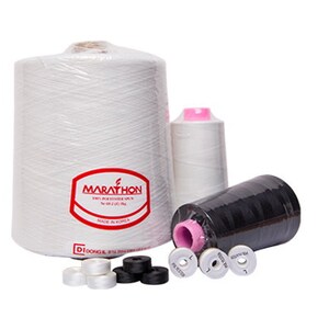 May include: White and black spools of thread with the brand name "Marathon" printed on the white spool. The spools are surrounded by small white bobbins.