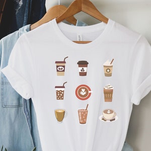 May include: White t-shirt with a graphic of nine different coffee drinks, including iced coffee, latte, cappuccino, and espresso.