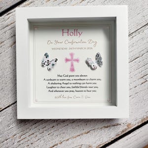 May include: A white framed Confirmation Day gift. The artwork includes the name "Holly" in pink, a pink cross, and butterfly accents. The text includes a date and a prayer.