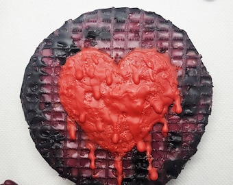 Pintura encáustica de un corazón sangrante.