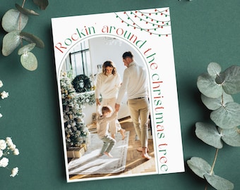 Puede incluir: Una tarjeta de Navidad con una foto de una familia de tres personas de pie frente a un árbol de Navidad decorado. El texto en la tarjeta dice "Rockin' around the Christmas tree".