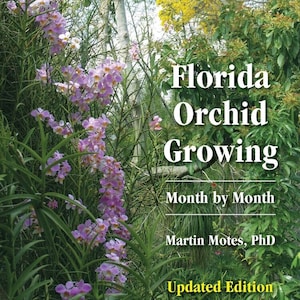 May include: Book cover featuring a close-up of pink orchids in a lush green garden. The title reads "Florida Orchid Growing: Month by Month" by Martin Motes, PhD. The book is an updated edition.