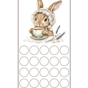 May include: A printable chart with a cute bunny rabbit drinking tea. The chart has 16 circles for a savings tracker. The text at the top says "Hoppy's Sips & Savings" and the text at the bottom says "The Enchanted Owl's Nest".