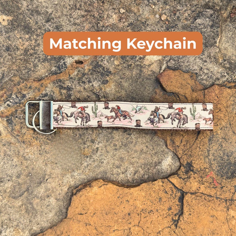 May include: A beige keychain with a repeating pattern of cowboys on horseback, cacti, and boots. The keychain has a silver metal clasp and the text "Matching Keychain" in an orange rectangle.