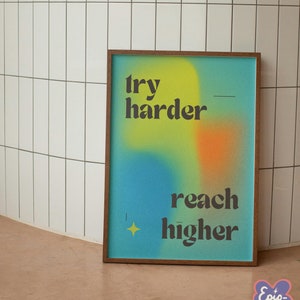May include: A framed motivational poster with a blue, yellow, and orange gradient background. The text on the poster reads "try harder - reach higher".