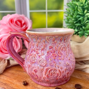 May include: A set of three ceramic mugs with a speckled, matte finish. The mugs are in shades of cream, light gray, and dark gray. Each mug has a simple, minimalist design and a rounded handle.