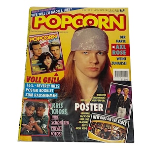 May include: A magazine cover featuring a photo of Axl Rose, the lead singer of Guns N' Roses, with the title "POPCORN" in large, yellow letters. The magazine cover also features photos of Kris Kross, Beverly Hills 90210, and New Kids on the Block.