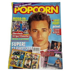 May include: A magazine cover featuring Luke Perry from the TV show Beverly Hills, 90210. The magazine is called "Popcorn" and is a German publication. The cover also features a collage of other stars, including Jason Priestley, Roxette, and Bon Jovi.