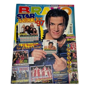 Peut inclure: Une couverture de magazine avec une photo d'un homme aux cheveux noirs portant une chemise bleue. Le magazine s'intitule "Bravo" et contient un calendrier pour 1997. La couverture présente également des photos de divers artistes musicaux, dont les Backstreet Boys, les Spice Girls et DJ Bobo.