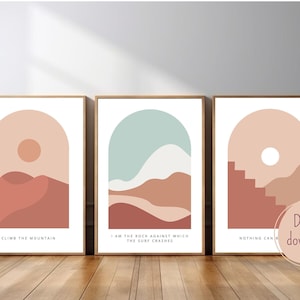 Puede incluir: Tres impresiones de arte de pared imprimibles con diseños de paisajes abstractos en tonos melocotón, marrón y verde azulado. Las impresiones presentan marcos arqueados y citas inspiradoras: "Escalar la montaña", "Soy la roca contra la que chocan las olas" y "Nada puede..."