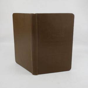 May include: A brown, hardcover book with the title "Dinsmore's Guide Book" embossed on the cover. The book is rectangular and appears to be in good condition. The spine is visible, and the pages are bound together.