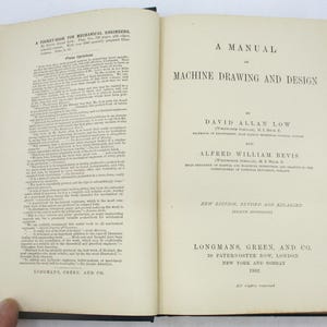 May include: A vintage book titled "A Manual of Machine Drawing and Design" by David Allan Low and Alfred William Bevis. The book cover is white with black text and is published by Longmans, Green, and Co. in 1902.