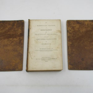 May include: Three antique books with brown leather covers. The middle book has the title "Elementary Treatise on Mensuration and Practical Geometry" printed on the spine.