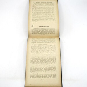 Peut inclure: Un gros plan d'une page d'un livre ancien sur les lentilles. Le texte traite de la diff&eacute;rence entre la r&eacute;fraction de la lumi&egrave;re et l'aberration chromatique des lentilles. La page est jaunie par le temps et a une surface us&eacute;e et textur&eacute;e.