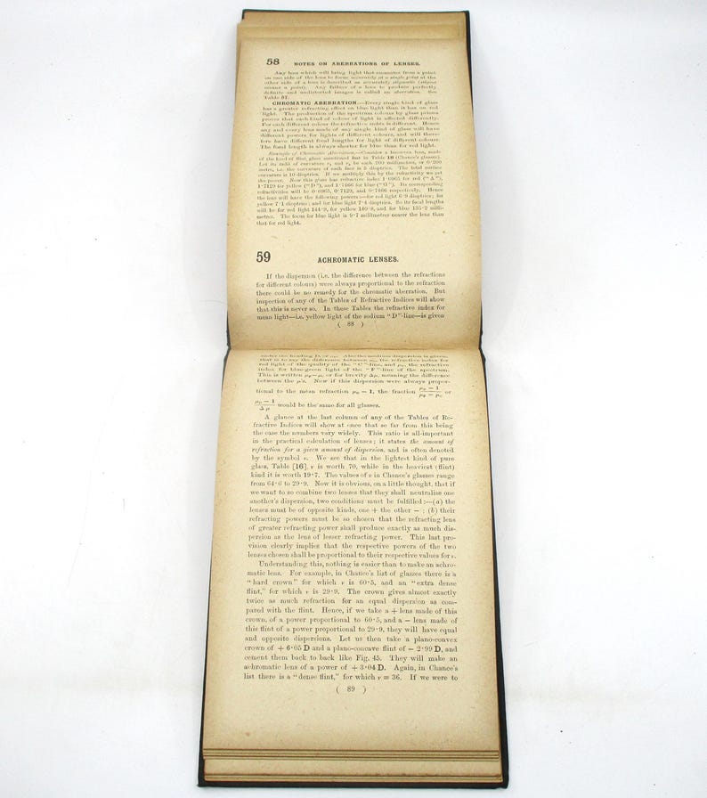 Peut inclure: Un gros plan d'une page d'un livre ancien sur les lentilles. Le texte traite de la diff&eacute;rence entre la r&eacute;fraction de la lumi&egrave;re et l'aberration chromatique des lentilles. La page est jaunie par le temps et a une surface us&eacute;e et textur&eacute;e.