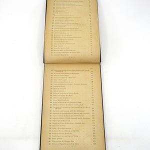 Peut inclure: Un livre vintage avec une couverture en cuir marron et des pages jaunies. Le livre est ouvert sur une table des mati&egrave;res avec des entr&eacute;es num&eacute;rot&eacute;es pour des sujets li&eacute;s &agrave; l'optique et &agrave; la vision.
