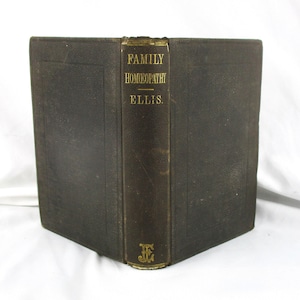 May include: An antique book titled "FAMILY HOMEOPATHY ELLIS" with gold lettering on the spine. The book has a dark brown leather cover with a textured appearance. The edges of the book are also dark brown.
