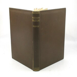 May include: A brown hardcover book titled "ENGINEERING DRAWING" with the author's name "FRENCH" in gold lettering. The book is open, revealing the pages, and the spine displays the publisher's name, "MCGRAW-HILL BOOK COMPANY."