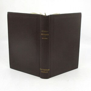 May include: A dark brown leather-bound book with gold lettering on the spine. The title is "Hydro-Mechanics" by Bowser. The book is published by D. Van Nostrand Company.