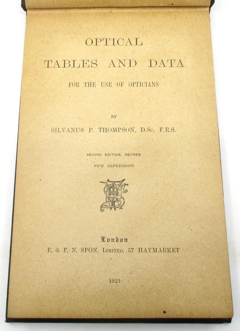 Peut inclure: Un livre intitul&eacute; "Optical Tables and Data" &agrave; l'usage des opticiens, par Silvanus P. Thompson, D.Sc. F.R.S. Deuxi&egrave;me &eacute;dition, r&eacute;vis&eacute;e. Nouvelle impression. Publi&eacute; &agrave; Londres par E. & F. N. Spon, Limited, 57 Haymarket en 1921.