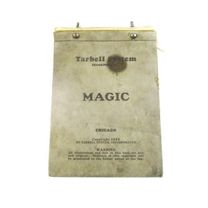 May include: A vintage book titled "MAGIC" by Tarbell System, Inc. The cover is a light tan color with the title in large, bold letters. The book is from 1926 and includes a copyright warning. The book is held together with metal fasteners.