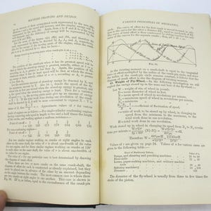 May include: A page from a book on machine drawing and design, with text and diagrams explaining the principles of mechanics, including the concept of a flywheel and its role in regulating speed. The text discusses the relationship between the weight of the flywheel, its speed, and the work it can store up.