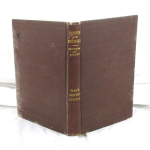 May include: A brown hardcover book titled Roofs and Bridges by Merriman and Jacoby, Part II Graphic Statics. The spine features gold lettering and the publisher name Wiley & Sons at the bottom. The book cover shows signs of wear and age.