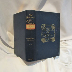May include: A dark blue hardcover book titled "The Genesis of Art-Form" with gold lettering and decorative accents. The book is part of a series called "Comparative Aesthetics".