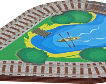 Könnte beinhalten: Ein Holz-Eisenbahnstück mit braunem und grauem Design. Die Schiene ist oval geformt und zeigt eine bemalte Szene eines Sees mit einem kleinen Boot und einem Holzsteg. Der See ist von grünem Gras und Bäumen umgeben.