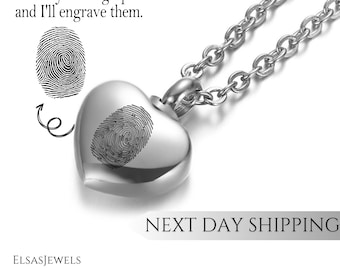 May include: A silver heart-shaped pendant necklace with a fingerprint engraving. The necklace has a chain and a heart-shaped pendant. Text on the image says, "Send me your fingerprints and I'll engrave them."