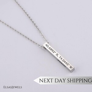 May include: Silver necklace with a bar pendant engraved with coordinates "40.6892° N, 74.0445° W" and the name "Jason".