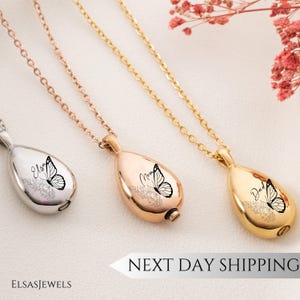Op de afbeelding: Drie traanvormige gedenkkettingen in zilver, ros&eacute;goud en goud. Elke hanger heeft een vlinderontwerp en gepersonaliseerde tekst. De kettingen hangen aan delicate kettingen. De tekst "Next Day Shipping" is zichtbaar.