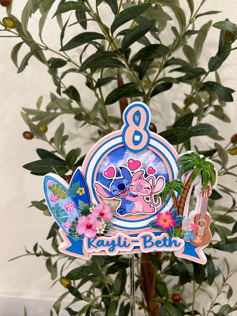 Może przedstawiać: Kolorowy topper na tort o tematyce tropikalnej z cyfrą 8. Zawiera deskę surfingową, palmę, ukulele i imię "Kayli-Beth". Projekt przedstawia postacie z kresk&oacute;wek obejmujące się, otoczone sercami i kwiatami.