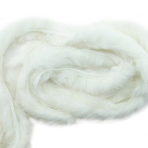 May include: A long strand of white faux fur trim. The fur is soft and fluffy, and it is perfect for adding a touch of luxury to any project.