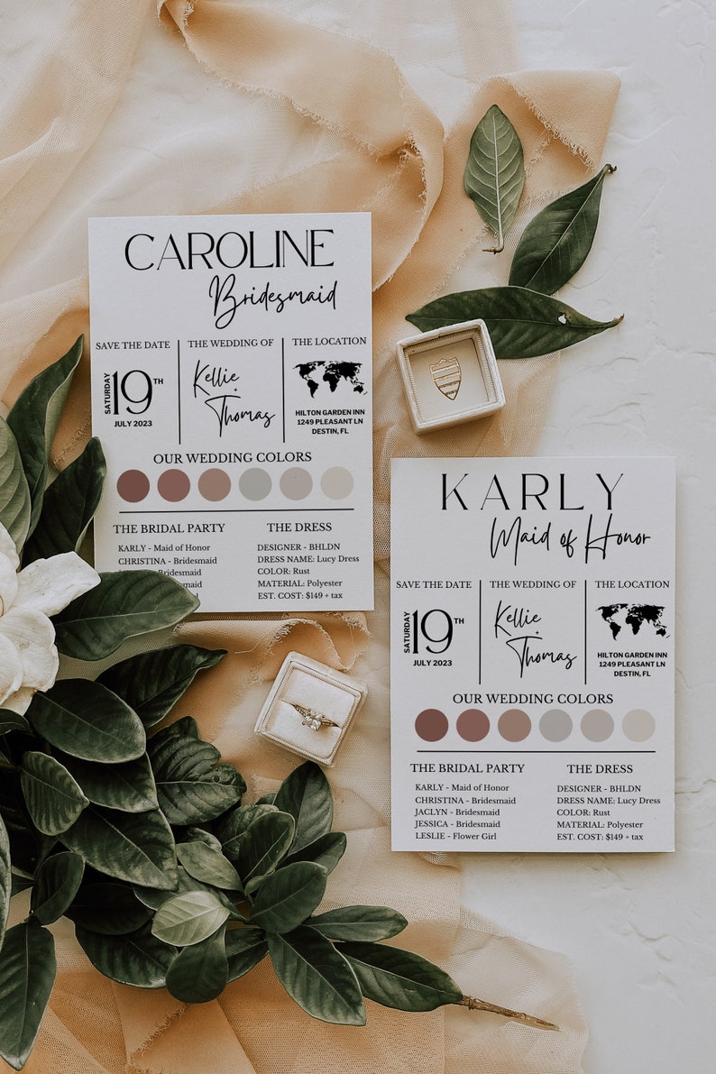 Peut inclure: Deux cartes d'invitation de mariage sur le th&egrave;me rustique. Les cartes sont d&eacute;cor&eacute;es de verdure et d'un &eacute;crin &agrave; bague. Le texte sur les cartes indique "Caroline Bridesmaid" et "Karly Maid of Honor". Les cartes indiquent &eacute;galement la date du mariage, les noms du couple et le lieu du mariage.