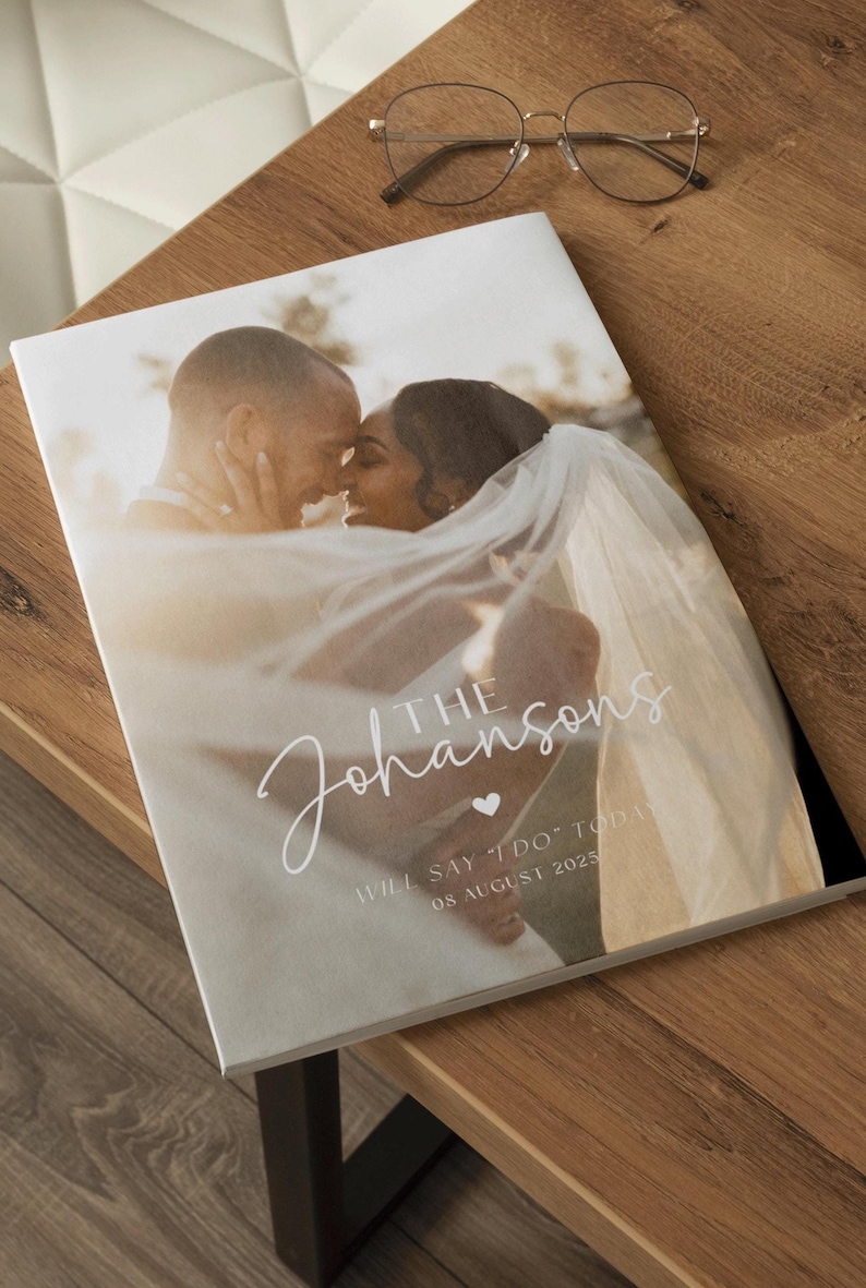 May include: A wedding invitation with a photo of a couple embracing. The invitation is white with a light brown background and features the text "The Johnsons" in a cursive font with a small heart symbol. The text "Will say "I do" today 08 August 2025" is also included.